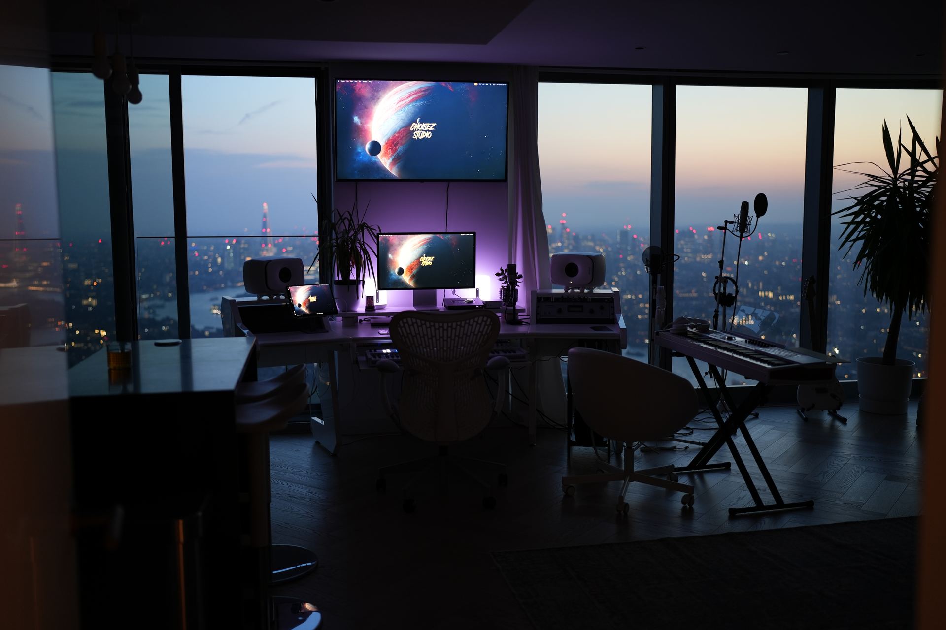 Choisez recording studio in London at night with the city skyline behind the desk