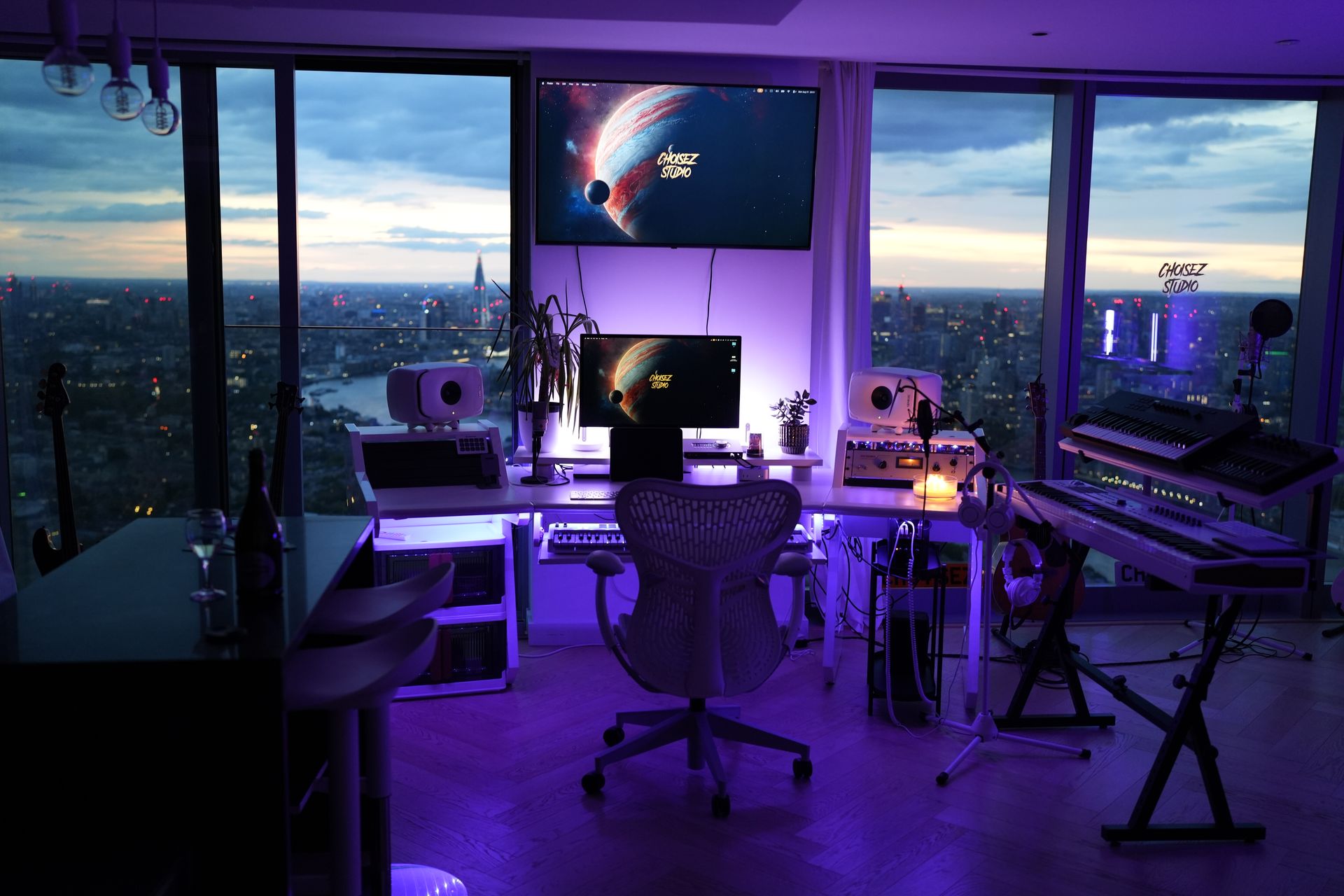 Wide view of the Choisez music production studio in London with skyline windows and keyboards